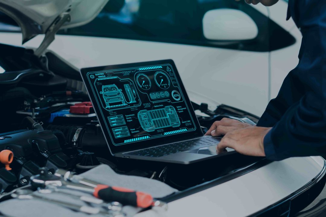 Técnico realizando diagnóstico electrónico de un automóvil con portátil